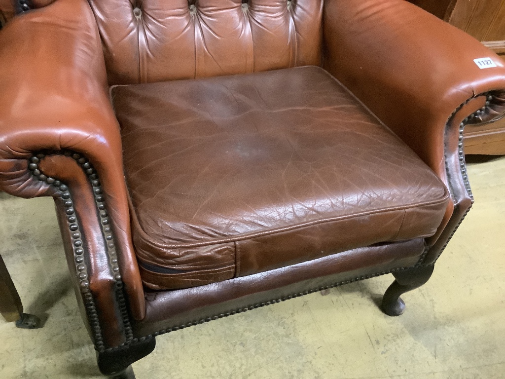 A buttoned burgundy leather wing armchair, width 86cm, depth 80cm, height 110cm